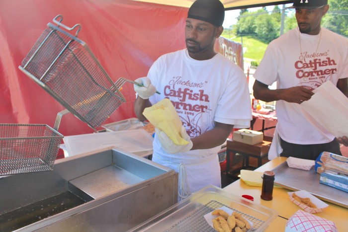 Montreal Jackson serves up some fries, as Terrell Jackson prepares an order at Jackson's Catfish Corner on Henderson and Rainier. (Photo by Venice Buhain.)