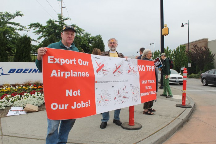The Washington Fair Trade Coalition and other labor groups demonstrated outside a visit by Secretary of State John Kerry at the Boeing plant in Renton. (Photo by Venice Buhain.) 