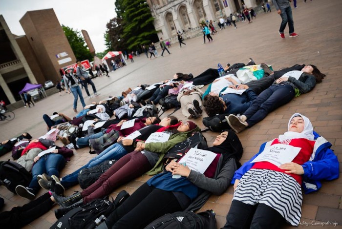 Senior Meva Beganovic, sophomore Rabbia Pasha and senior Yasmeen Samad (right to left) lie silently among the sea of die-in protestors, while students passing by on their way to classes look on. (Photo by Aditya Ganapathiraju)