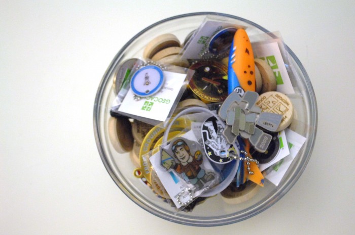 A bowl of geocoins and travel tags sits on the desk of a Geocaching.com Lackey at Geocaching headquarters in Fremont. (Photo by Joanna M. Kresge)