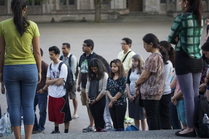 People partake in a moment of silence during a vigil on the UW campus May 29, 2015 put on by the Nepalese Student Association at UW. (Photo by Kelsey Hamlin)