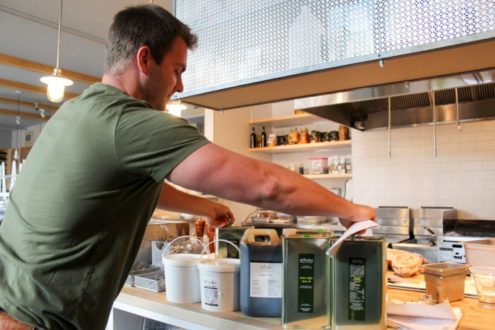 Tasos Manouras, owner of Ariadne Pure, delivers olive oil, vinegar and other products to Capitol Hill restaurant Omega Ouzeri. (Photo by Venice Buhain.)