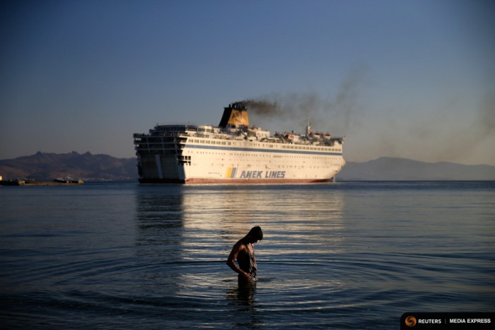 A migrant washes as the passenger ship "Eleftherios Venizelos" leaves the port on the Greek island of Kos. The passenger ship carrying Syrian refugees set sail from the Greek island of Kos in mid-August, heading for the mainland as authorities struggle to cope with a wave of arrivals. (Photo from REUTERS/Alkis Konstantinidis)