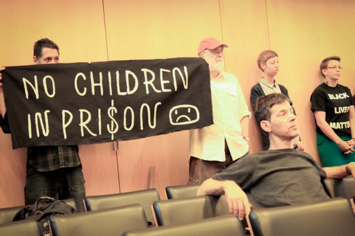 Members of anti-racist group holding a sign at the City Council committee hearing on Wednesday. (Photo by Goorish Wibneh)