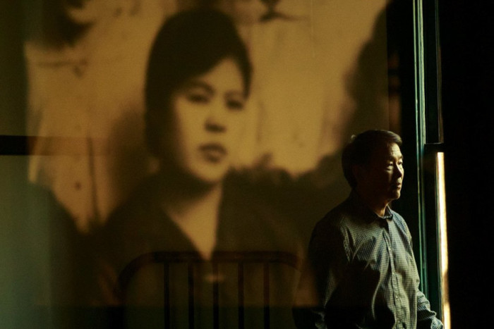 At the Wing Luke Museum last month, Densho Executive Director Tom Ikeda’s reflection is seen in a display of historical images from the region. Ikeda talked about the Japanese American legacy project. (Erika Schultz / The Seattle Times) 