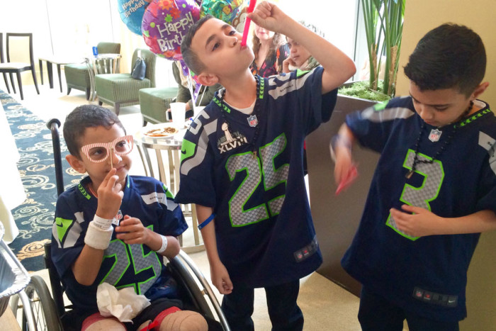 Shoulub (left) jokes around with new friends wearing matching Seahawks jerseys at the birthday party in Bellevue. Despite having the amputations just ten days prior, he was all smiles on Saturday. (Photo by Varisha Khan)