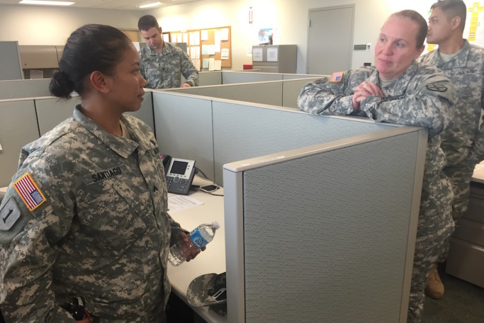Sgt. Santiago (left) talks to Master Sgt. Georgia Warrix (right) at her cubicle at the Marysville Armed Forces Reserve Center as she packs up to leave on Sunday, November 15. (Photo by Kayla Roberts)