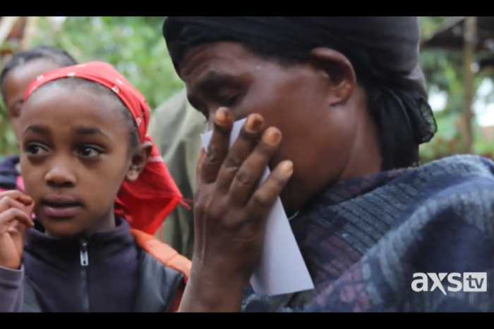 Almazay, a woman in Ethiopia, kisses a photo of her daughter, Senait, who was adopted in the United States. (Still from Unwanted in America)