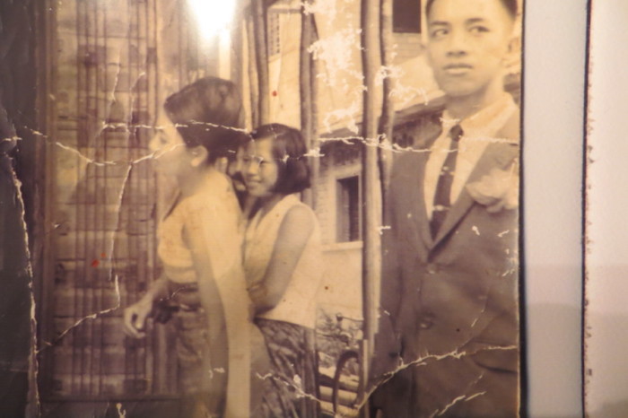 A tattered photo of the author's mother Sivorn (far left) and father Vuthy (far right) on their wedding day. (Photo courtesy of Samantha Pak)