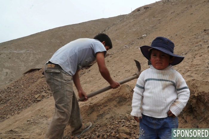 Kenneth stands by as his father, Alfredo, digs the foundation for their first home in Manchay. (Photo by Rustin Thompson)