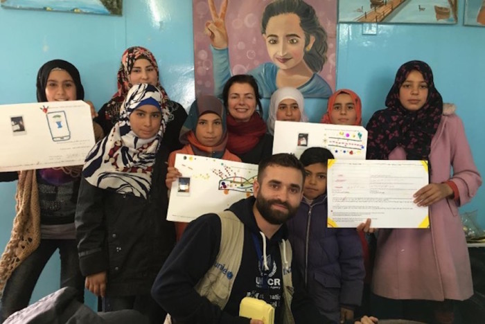 UW professor Karen Fisher (center, back row) and a UNHCR interpreter (center, front row) pose with Syrian teens holding Magic Genius Device prototypes they created during a participatory design workshop at Za’atari Refugee Camp in Jordan in November 2015. (Photo courtesy of Karen Fisher, University of Washington Information School)