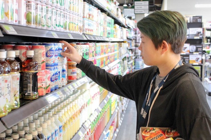 Bellevue High School student Jennifer Morss picks out a drink as she stops at the Bellevue H-Mart for lunch. (Photo by Venice Buhain.)