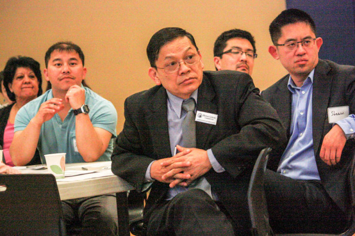 Mohan Gurung of the Washington Commission on Asian Pacific American Affairs (center) and other attendees listen at a recent forum on Washington state legislative bills affecting people in the Asian American community. (Photo by John Stang.)