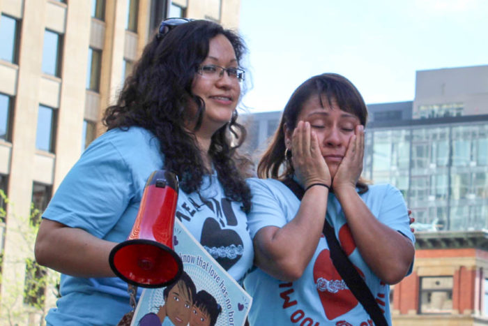 Maricela Osorio (right) wipes her eyes after getting emotional addressing a crowd at a rally supporting Obama's immigration actions in front of the federal building in downtown Seattle, while Casa Latina organizer Cariño Barragán (left) comforts her. (Photo by Venice Buhain.)