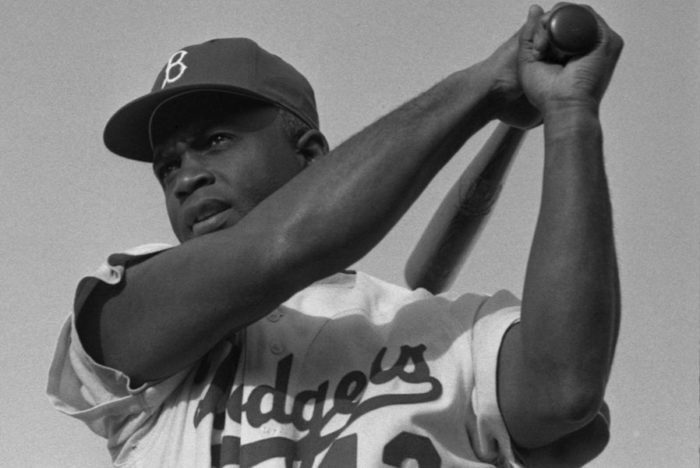 Jackie Robinson posing in his Dodgers uniform in 1954. (Photo by Bob Sandberg and reprinted under a Creative Commons License)