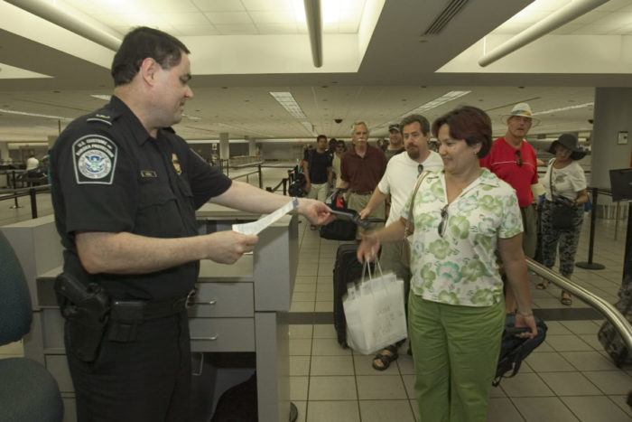 A U.S. Customs and Border Protection officer checks a passenger's documentation after arriving to the U.S. (Photo by the U.S. Customs and Border Protection.)