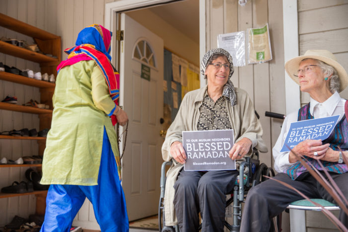 Seattle-area Quakers sit at the women's entrance of the Islamic Center of Federal Way, to show solidarity at the final Jummah of Ramadan. (Photo by Alex Garland.)