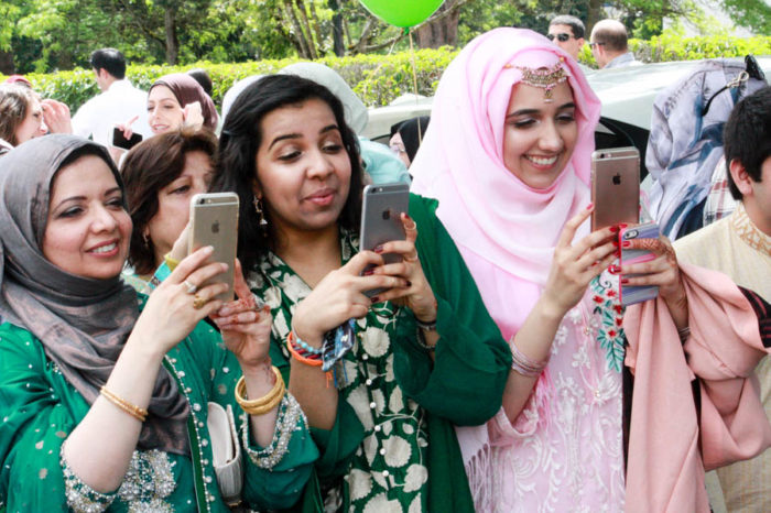 Mosque members get ready to celebrate Eid by taking selfies outside the Muslim Association of Puget Sound's masjid in Redmond. (Photo by John Stang.)