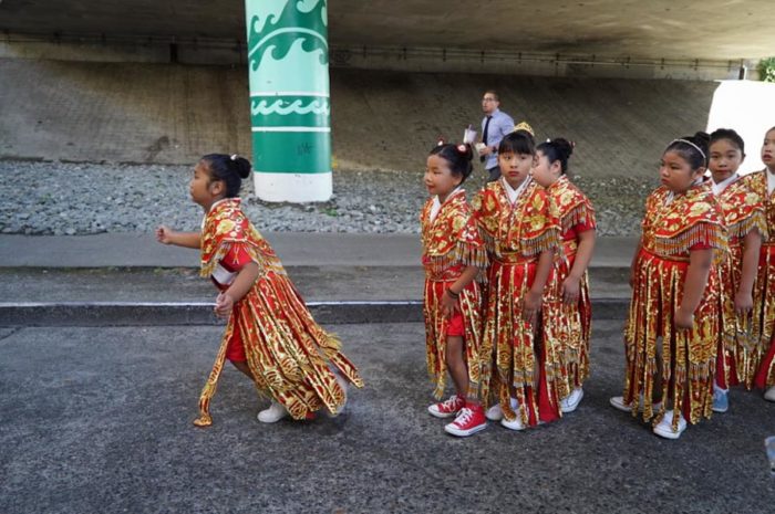 Smaller members of the Chinese Community Drill Team run to catch up.