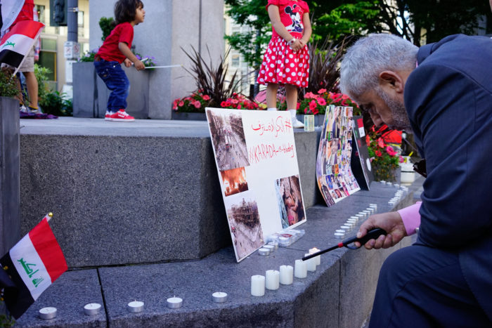 A man lights a candle at a vigil for Iraq at Westlake Park Wednesday night. (Photo by Chloe Collyer)