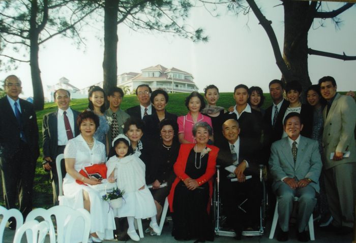 The author sits in her mother's lap at a family wedding in 1999, surrounded by her immediate and extended family