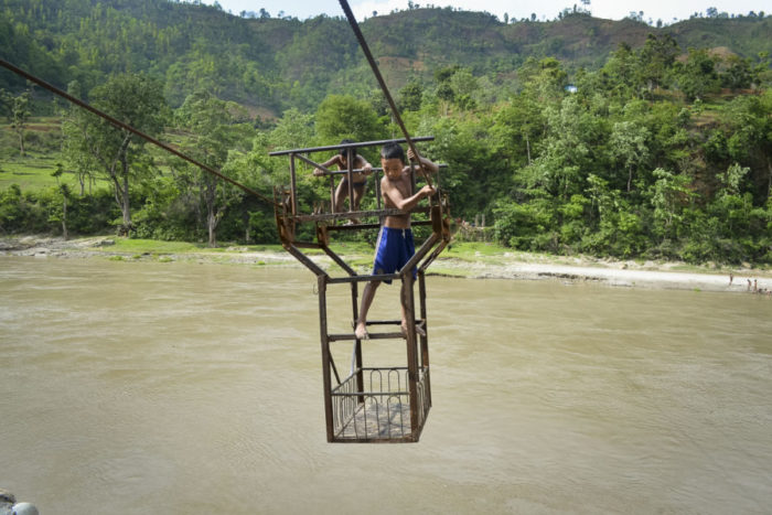 Children enjoy a risky ride in a tuin, a rope and pulley system, over the Trishuli River in Nepal’s Dhading district. The government plans to replace all 155 of Nepal’s tuins with suspension bridges. (Photo by Kalpana Khanal, GPJ Nepal)