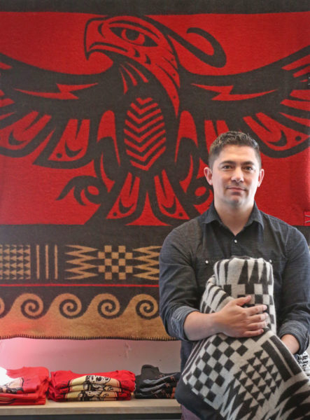 Native artist Louie Gong with blankets he designed and will sell at his new store,"Eighth Generation"opening Saturday in the Pike Place Market. (Photo by Greg Gilbert / The Seattle Times)