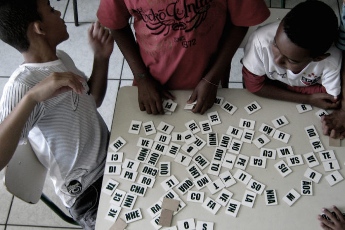 Children play word dominoes in an afterschool program in the Heliópolis favela in São Paulo. (Photo by Bruno Ruiz)