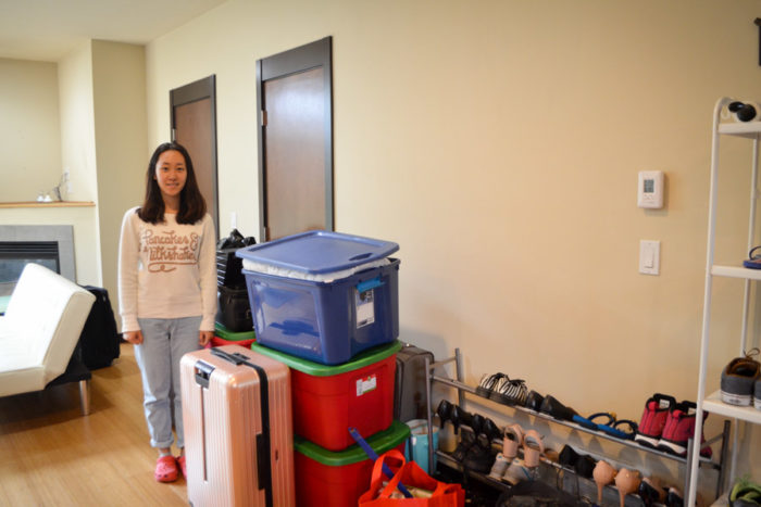 Sylvia Zhao stands by her unpacked boxes in the living room of the new townhouse she just moved into. (Photo by Katherine Jinyi Li)