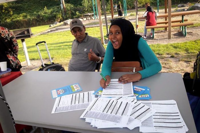 A student volunteer helps people register to vote in advance of the September voting workshop at Somali Community Services of Seattle. (Photo courtesy of Sahra Farah)