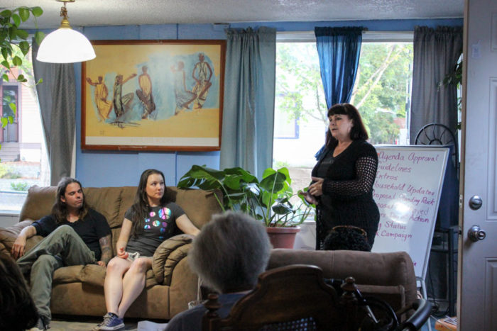 Pina Orsillo Belgrano, right, who fought foreclosure on her own home in Beacon Hill, addresses a meeting of SAFE volunteers in the Slack's living room. (Photo by Alia Marsha)