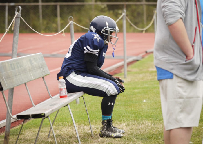Byron Jones of the Cowboy Juniors waits on the bench before going back out on the field against the Renton Rangers.