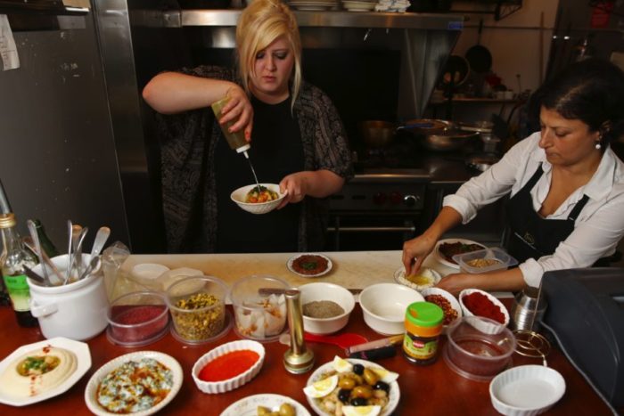 "Yalla," a middle-eastern food popup restaurant in the Central District has chefs Taylor Cheney, left, and Pinar Ozhal, right, busy in the kitchen of The Atlantic restaurant, Monday, Oct. 3, 2016, in Seattle. The Middle Eastern pop-up focuses on conflict region food, with tonight emphasizing dishes from Kurdistan. (Photo by Ken Lambert for The Seattle Times.)