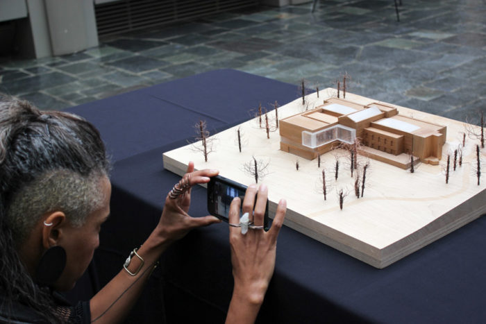 At a community outreach meeting Cayetana San Segundo takes a photo of a model of what the new Seattle Asian Art Museum will look like in 2019. (Photo by Alia Marsha)