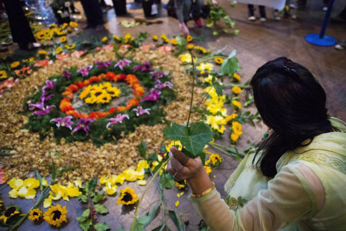 Puja Chauhan helps create flower rangoli art, led by artist Annie Penta, during a Festival of Lights Diwali celebration at the Seattle Center Armory in 2014. (Lindsey Wasson / The Seattle Times)