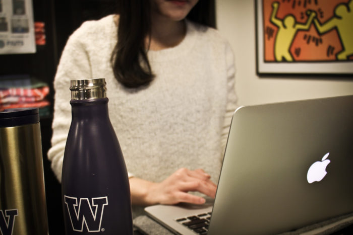 Cecilia Zhong uses a computer at FIUTS, a nonprofit that helps international students adjust to life at UW — and avoid becoming targets of scammers. (Photo by Bernard Ellouk)