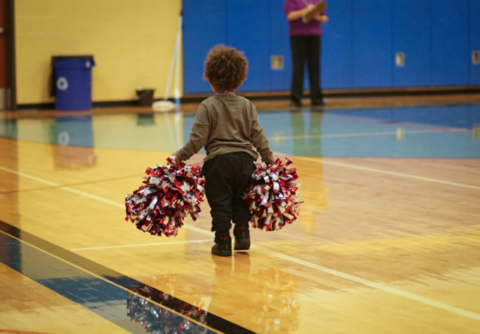 A little boy helps pick up pompoms after the Renton Rangers competition-winning performance. (Photo by Susan Fried)