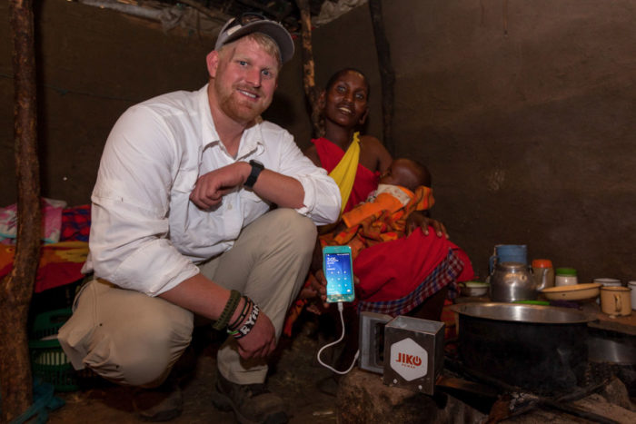 Ryan Ahearn with a JikoPower user in Kenya. The spark's copper prong is placed in a cook fire then heat is transferred to a cup filled with water, sends power to the usb charging port. (Courtesy photo)