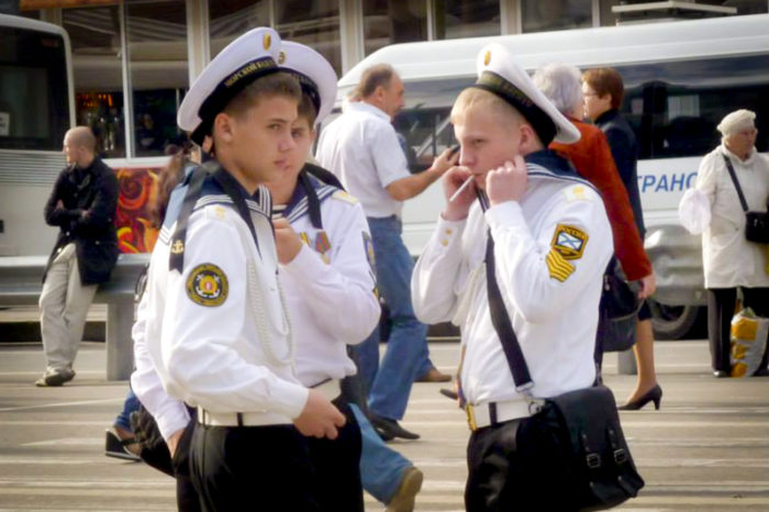 Young men in Russian navy uniforms outside a Moscow train station. (Photo by Joe Kilroy)