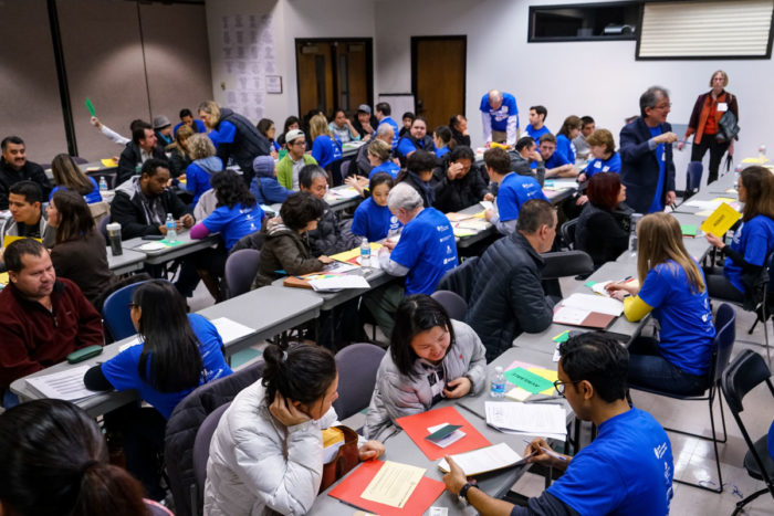 At a citizenship workshop held in 2016, volunteers help immigrants fill out intake forms to determine any potential issues with the citizenship application process. (Photo by Alabastro Photography)