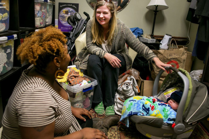 Suzanne Brewer Melchor, center, and her son Mateo, are greeted by outreach birth doula Rokea Jones in the baby boutique room at Open Arms Perinatal Services. (Photo by Johnny Andrews / The Seattle Times)