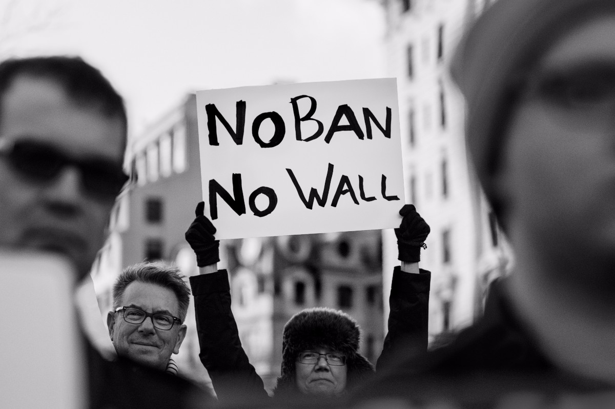 A protester holds a sign during a rally against President Donald Trump's initial travel ban in January. (Photo by Lorie Shaull via Flickr)