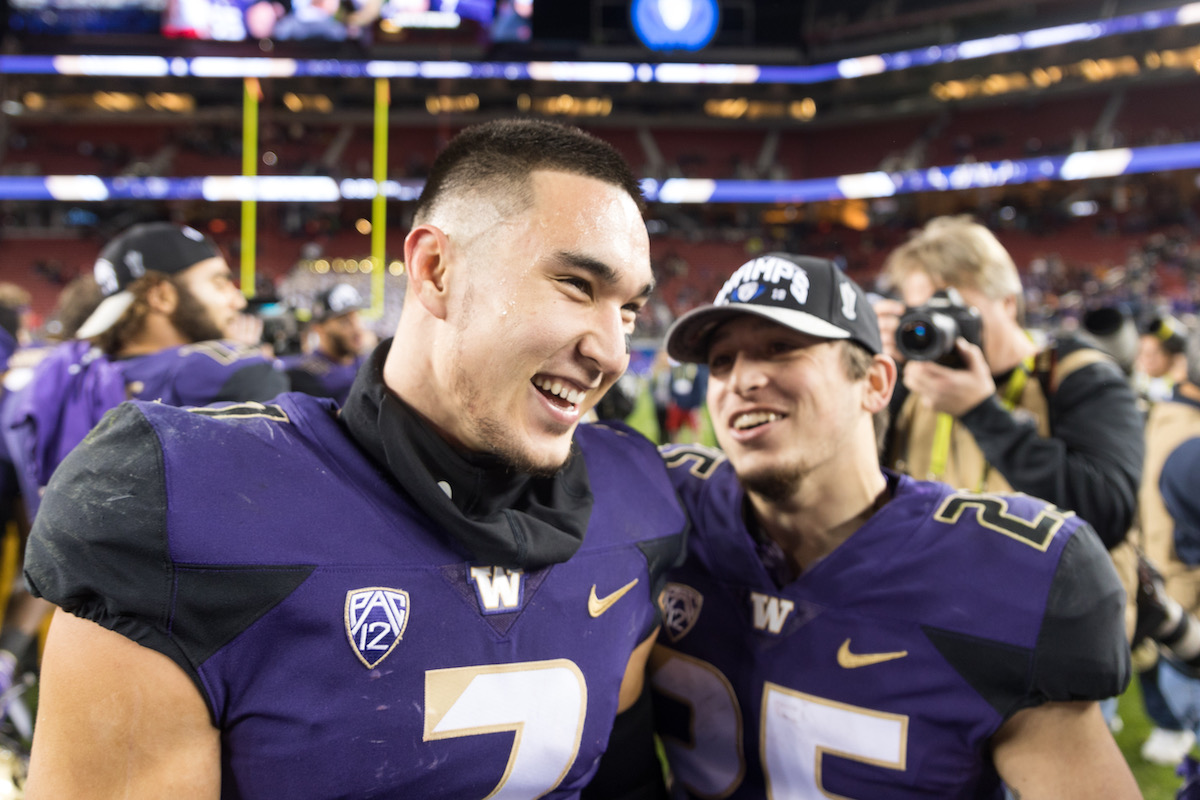 Taylor Rapp (left) celebrates winning the Pac-12 championship with Sean McGrew (right) after Washington defeated Utah 10-3. Rapp is entering the NFL Draft this year, and will hope to be the first Chinese American selected since 2010. Photo Credit: Conor Courtney