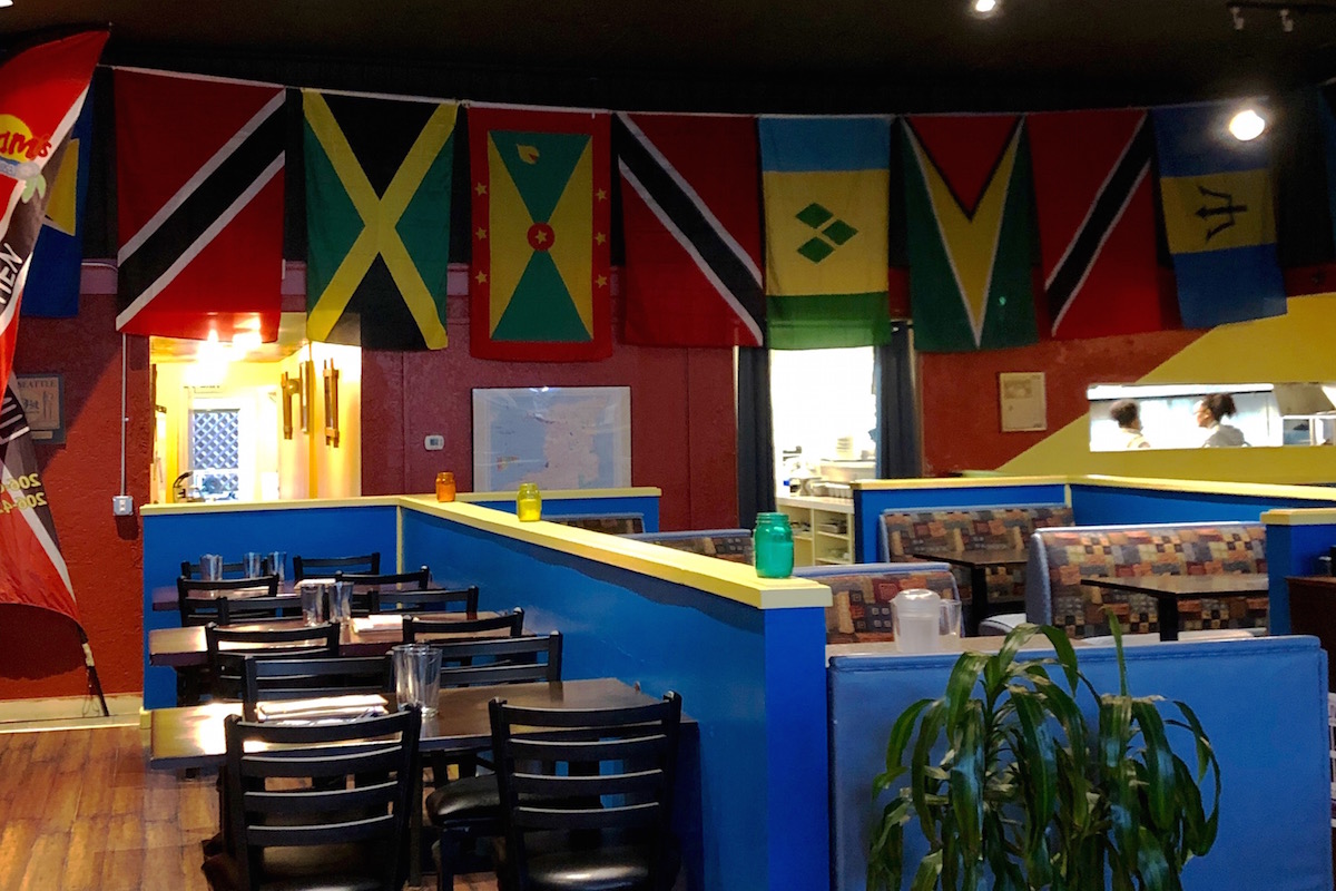 Caribbean flags adorn the colorful walls inside Pam's Kitchen in Wallingford, Seattle. Pamela Jacob, owner and cook at Pam's Kitchen is originally from Trinidad, but moved to Seattle in 1994 to stay with family. (Photo by Alexandra Polk)